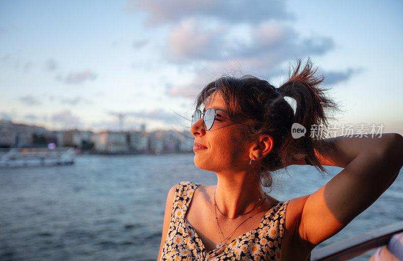Portrait of young tourist woman in front of Istanbul cityscape at sunset.